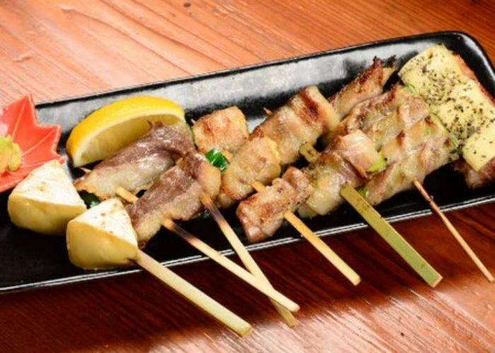 A variety of skewered meats on a serving tray at Sumiyaki Kaminari Main Store.